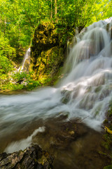 Obraz premium Beautiful waterfalls in spring in the forest, on a bright sunny day