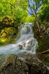 Fototapeta na wymiar Beautiful waterfalls in spring in the forest, on a bright sunny day