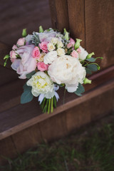 bouquet of white and pink peonies and garden roses outdoors on wooden background