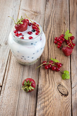 granola and yogurt with berries on the old wooden background.
