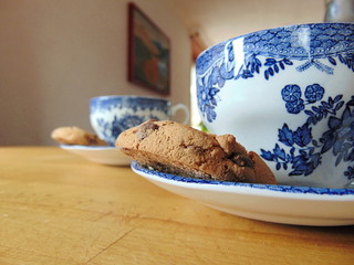 cup of tea with chocolate chip cookie on saucer | hot drink