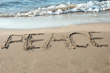 Peace written in the sand on the beach