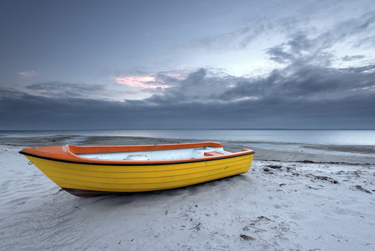 Yellow boat on the beach in cloudy day. Baltic Sea. Poland.