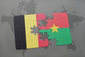 puzzle with the national flag of belgium and burkina faso on a world map background.