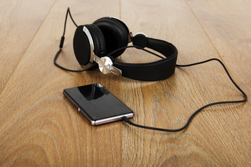 Headphones and phone on a wooden surface