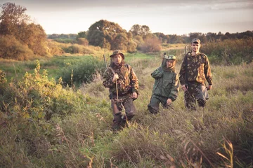 Cercles muraux Chasser chasseurs passant par grand garass in rural field à l& 39 aube pendant la saison de chasse