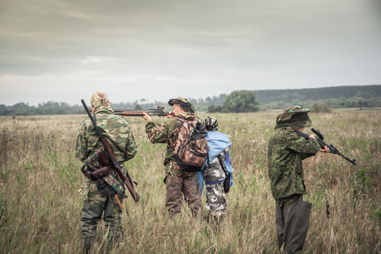 Hunters preparing for hunting in rural field in overcast day during hunting season