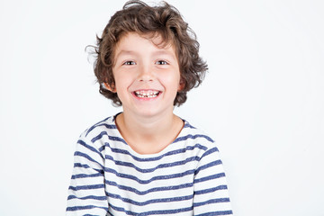 Close up portrait of happy cute little boy with curly hair