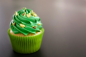 Pistachio cupcake on dark background