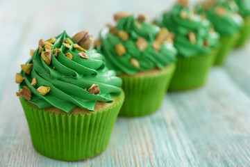 Pistachio cupcakes on wooden table
