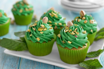 Pistachio cupcakes with mint leaves on plate