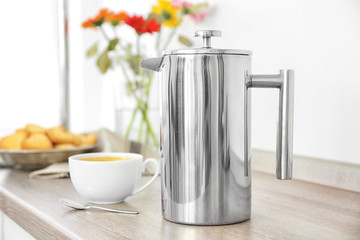 Coffee maker and breakfast with flowers on blurred background