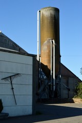 Grain silos in front of a barn.