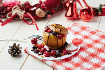 Baked apple with berries and chocolate sauce. Wooden background. Healthy lifestyle.Diet and weight loss concept. Low calories dinner. Vitamin B. Healthy food.