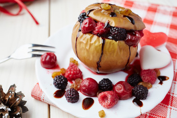 Baked apple with berries and chocolate sauce. Wooden background. Healthy lifestyle.Diet and weight loss concept. Low calories dinner. Vitamin B. Healthy food.