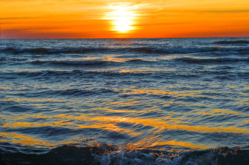 Fototapeta premium Brilliant sunrise over the waters of lake Huron in Oscoda, Michigan