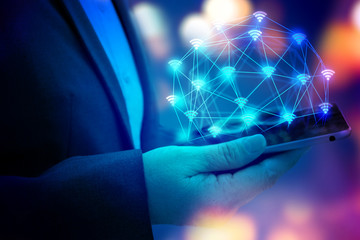 Internet of things (IOT) concept . Business woman hand holding tablet with Wifi connect icons with bokeh abstract background. blue tone image