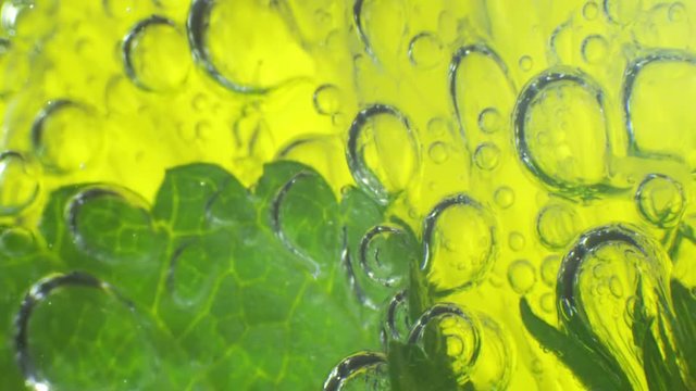 Sparkling bubbles water with a slice of lime. Slow motion macro footage.