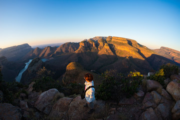 Blyde River Canyon, famous travel destination in South Africa. Tourist looking at panorama at sunset. Last sunlight on the mountain ridges. Fisheye distorted view from above.
