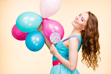 Woman with colorful balloons and lollipop