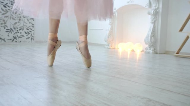 Close up of a ballet dancer's feet. Girl dancing in white room