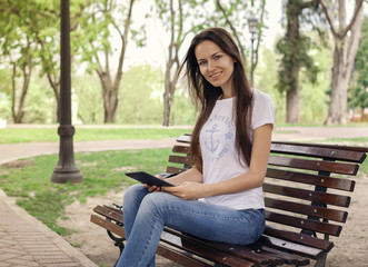 Beautiful girl with a e-book in the park