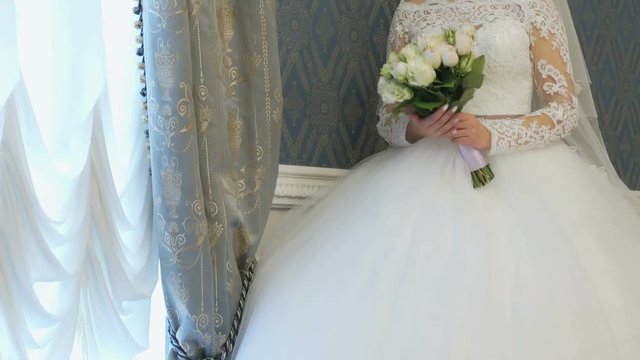 Bride stands next to window during photo session