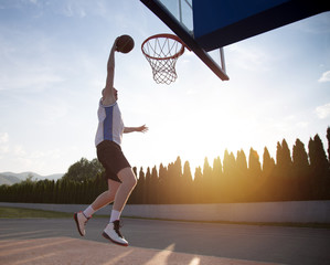 Young man jumping and making a fantastic slam dunk playing stree © FS-Stock