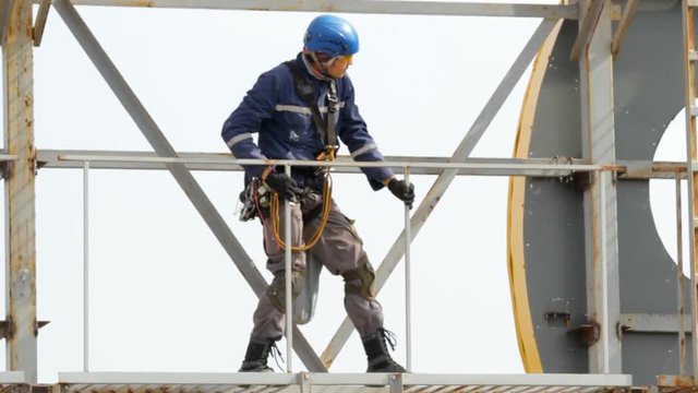 Industrial Climber Works at a Height of Weld Design.