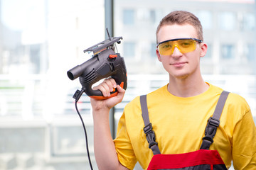 Young construction worker in yellow coveralls