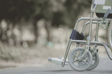 Fototapeta na wymiar Empty wheelchair parked in park, retro filter effect