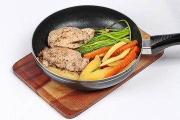 Home made ,Cooking pork steak with mixed vegetables in pan before served isolated on background.