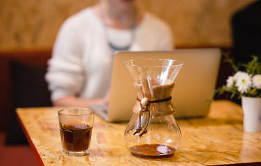 Russian girl is drinking coffee in a cafe with a laptop