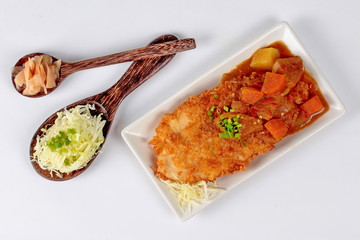 Japanese style  of deep fried dolly fish topped yellow curry with sliced cabbage and pickled ginger.