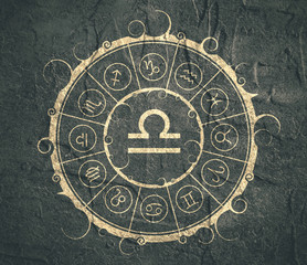 Astrological symbols in the circle. Concrete wall textured. Scales sign