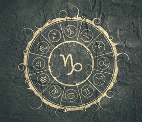 Astrological symbols in the circle. Concrete wall textured. Capricorn sign