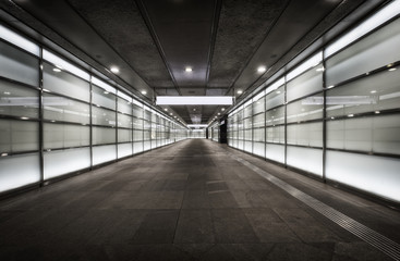 Empty corridor at night with glass illuminated walls