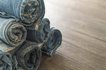 stacks of jeans clothing on wood