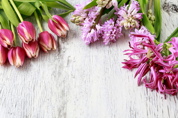Tulips and hyacinths on wooden background