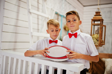 Two brothers posed at studio room and hold a ball for rugby