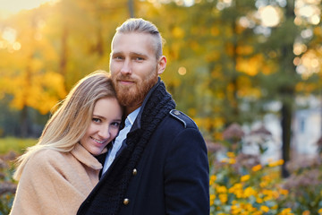 Redhead bearded male hugs the cute blonde female.