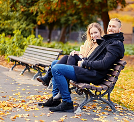 A man and a woman sits on a bench.