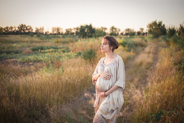 Portrait of a pregnant woman in the sunset light