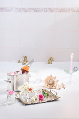 Fototapeta na wymiar a bubble bath with champagne, red velvet cupcakes and seashell decorations, clean and pinky