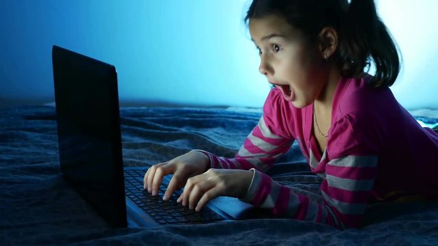 Teen angry girl evil surprise working at laptop, the Internet play in the online entertainment game