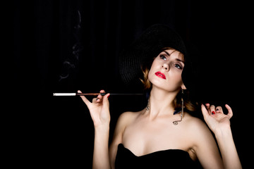 Beauty retro female model with professional makeup and mouthpiece in hand. fashion vintage woman on a dark background