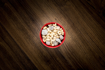 Bowl of cashew nuts and figs from above. Wooden background