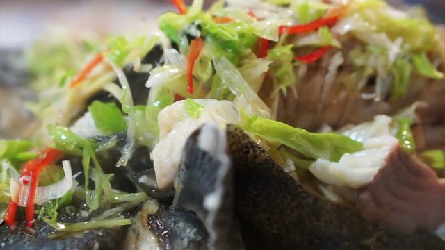 Asian Chinese style whole fish steamed with soy sauce and spring onion topping