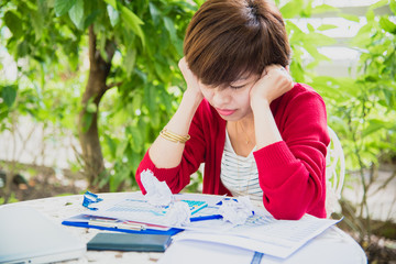 Top view of young working woman using laptop and reading annual report document at work. Business woman working at her desk.