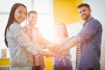 Obraz premium Portrait of smiling business people stacking hands